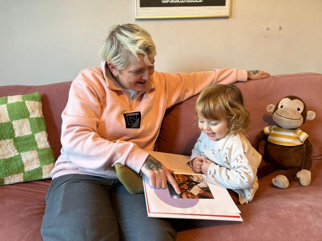 Parent and child reading their storybook together, celebrating the love and intention captured in their family story