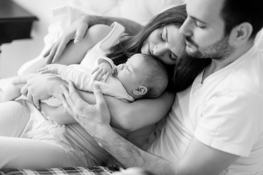 New parents holding their newborn baby after a successful surrogacy journey