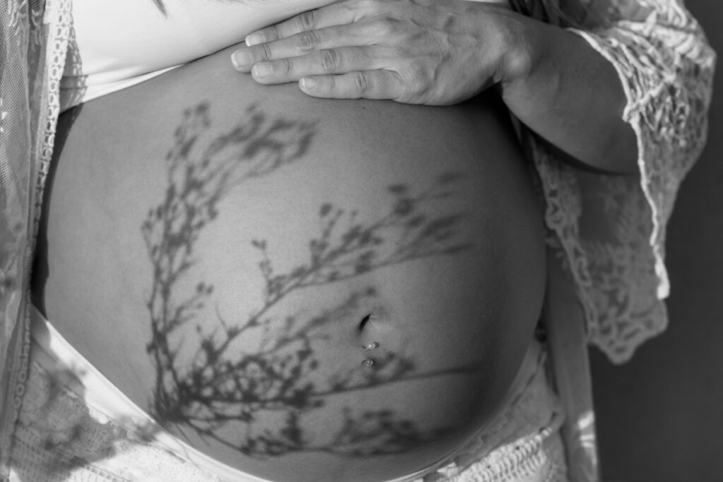 Pregnant woman's belly with hand resting on top
